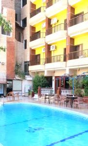 a large swimming pool in front of a building at New Radwan Hotel, Luxor railways in Luxor