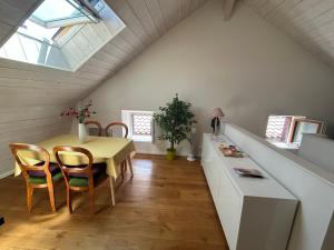 a dining room with a table and chairs in a attic at La Pistacherie à 30m de la plage de Grande Rive in Évian-les-Bains