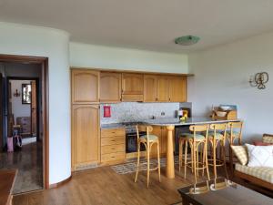 a kitchen with wooden cabinets and a table with bar stools at Glicine in Carlazzo