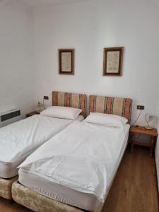 a bedroom with two beds and two pictures on the wall at Glicine in Carlazzo