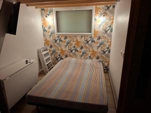 a room with a bed and a television on a wall at Studio Cosy proche Futuroscope in Montamisé