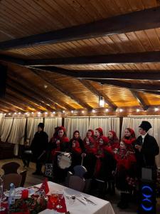 a group of women sitting in a room with a man at PENSIUNEA TEOMIR in Pojorâta