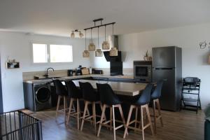 a kitchen with a table with chairs and a refrigerator at O Ptit home in Saint-Vincent-sur-Jard +7 photos