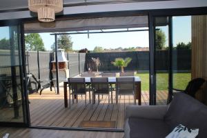 a screened in porch with a table and chairs at O Ptit home in Saint-Vincent-sur-Jard
