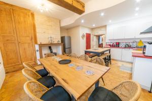 a kitchen and dining room with a wooden table and chairs at L Ancestral in Beaumont-les-Autels