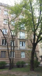 a building with two trees in front of it at Zoli Apartment in Warsaw