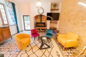 a living room with chairs and a fireplace at L Ancestral in Beaumont-les-Autels