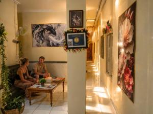 a couple sitting on a couch in a living room at Medan Dazhong Backpacker's Hostel in Medan