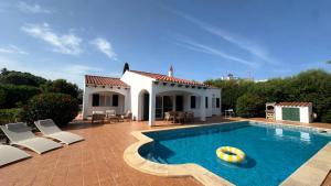 a swimming pool with chairs and a house at 6 person house with private pool and garden in Trebeluger