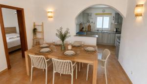 a kitchen and dining room with a wooden table and chairs at 6 person house with private pool and garden in Trebeluger
