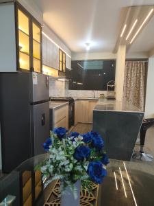 a kitchen with a vase of blue flowers on a glass table at DEPPIu in Piura