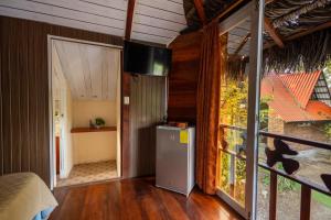 a room with a refrigerator and a sliding glass door at QUINTA PRIMAVERA - Hostería Campestre in Nueva Loja