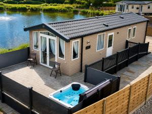 a large deck with a tiny house with a hot tub at Parkside Fishery in Skegness