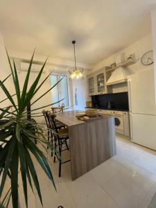 a kitchen with a table and a white refrigerator at Boka view Heritage Apartment in Herceg-Novi