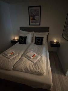 a bedroom with a white bed with two towels on it at Ytterland Apartments in Ålesund
