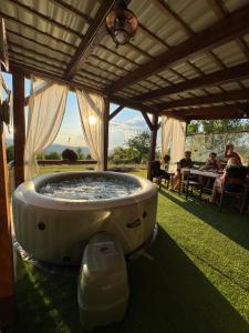 a large bath tub sitting under a pergola at Căsuța Rustică in Muncelu Mare