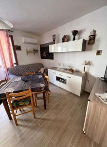 a living room with a table and a kitchen at Maison di Mario in Tresnuraghes