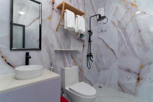 a white bathroom with a marble wall at Nest and nook in Ukulhas