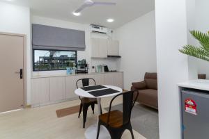 a kitchen and living room with a table and chairs at Nest and nook in Ukulhas