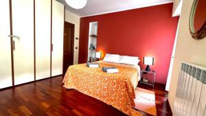 a bedroom with a bed with a red wall at Crotto bedroom in Argegno