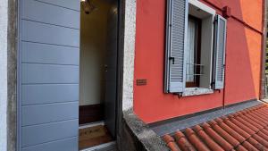 a red and white house with a window at Crotto bedroom in Argegno +4 photos