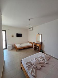 a bedroom with a bed and a television in it at Paradise Matala Hotel in Matala