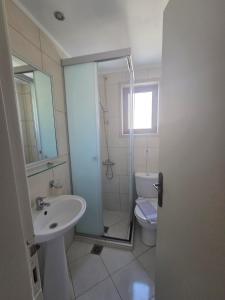 a bathroom with a shower and a sink and a toilet at Paradise Matala Hotel in Matala +61 photos