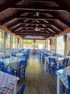 a dining room with blue tables and blue chairs at Paradise Matala Hotel in Matala
