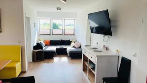 a living room with a couch and a flat screen tv at Admiralshütte XXL - für 12 Personen zwischen Dornumersiel und Bensersiel in Dornum