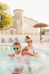two children are sitting in a pool in the water at Château De Chaussy in Ruoms