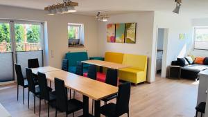 a dining room and living room with a table and chairs at Admiralshütte XXL - für 12 Personen zwischen Dornumersiel und Bensersiel in Dornum