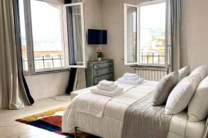 a bedroom with a large bed with two windows at Signature Design & Panoramic Views in Montecatini Terme