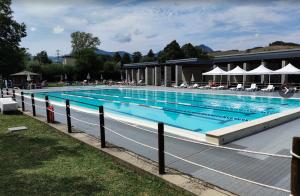 a large swimming pool with chairs and umbrellas at Albergo Ristorante La Rocca in Firenzuola