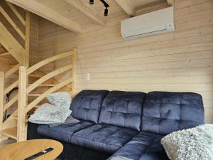 a living room with a black leather couch in a cabin at Domki Łomnicka Ostoja in Łomnica