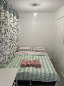 a bed with two brown slippers sitting on it at Private studio with a private bathroom and kitchenette in Edmonton