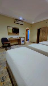 a hotel room with two beds and a television at فندق نسك الفضيلة in Ajyad