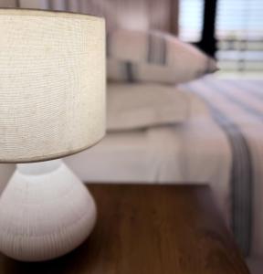 a white lamp sitting next to a bed at 33D Kabeljauws Beach in Jeffreys Bay