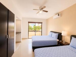 a bedroom with two beds and a ceiling fan at Encanto Riviera in Playa del Carmen +34 photos