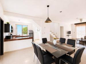 a dining room and kitchen with a table and chairs at Encanto Riviera in Playa del Carmen