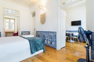a bedroom with a white bed and a dining room at Gonzalo's Guest Apartments - Downtown Historic Flats in Lisbon