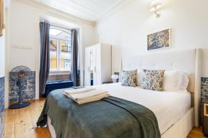 a bedroom with a large white bed and a window at Gonzalo's Guest Apartments - Downtown Historic Flats in Lisbon