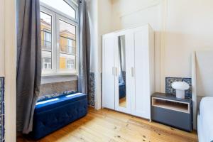 a bedroom with a large window and a blue bench at Gonzalo's Guest Apartments - Downtown Historic Flats in Lisbon +25 photos