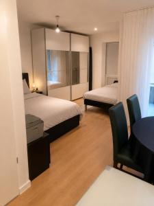a hotel room with two beds and a table and chair at Apartment am Rhein in Bonn