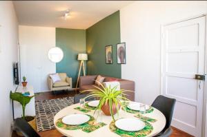 a dining room with a table and a couch at Apartamento T3 Belém in Maputo