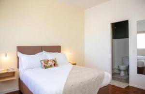 a bedroom with a large white bed with a pillow at Apartamento T3 Belém in Maputo