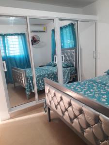 a bedroom with two beds and a mirror at SDQ Apartamento in Los Tres Ojos de Agua