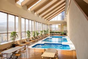 an indoor pool in a building with tables and chairs at Crowne Plaza Hotel Monterrey by IHG in Monterrey