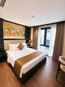 a hotel room with a large bed and a window at Halo hotel & Spa hanoi in Hanoi +12 photos