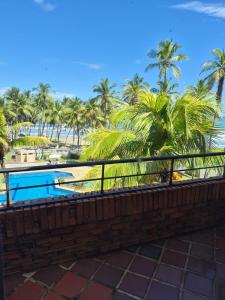 a balcony with a view of the beach and palm trees at relax en tucacas in Boca de Aroa