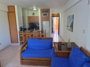 a living room with a blue couch and a kitchen at relax en tucacas in Boca de Aroa